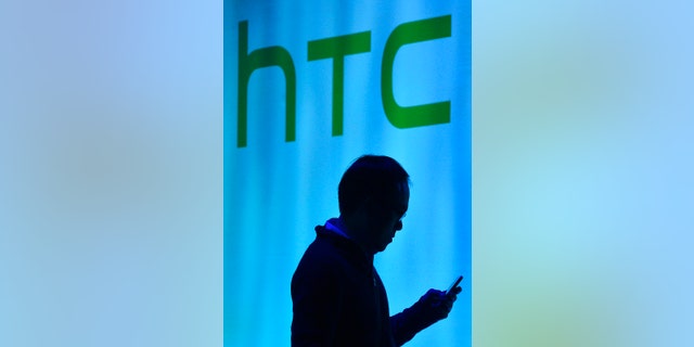 File photo - A man uses his mobile phone during the launch of the HTC One smartphone in London Feb. 19, 2013. (REUTERS/Toby Melville)