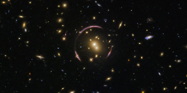 The graceful arcs at the center of this image from the Hubble Space Telescope are actually the distorted light of distant galaxies, twisted to form an "Einstein ring" by the gravitational influence of the closer galaxy cluster SDSS J0146-0929.