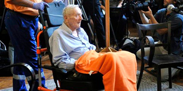Former Hungarian gendarme captain Sandor Kepiro sits in a wheelchair in the courtroom prior to the verdict in the Municipal Court of Budapest, Hungary, Monday, July 18, 2011.