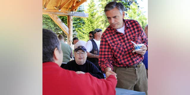 With his wife Mary Kaye at his side possible 2012 presidential hopeful, former Republican Gov. Jon Huntsman, Jr., of Utah shakes hands during a cultural festival at Heritage Park, Saturday, June 4, 2011 in Berlin, N.H. (AP Photo/Jim Cole)