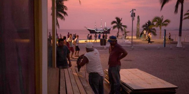 People preparing for the arrival of Hurricane Patricia board up the windows of a seaside business in the Pacific resort city of Puerto Vallarta, Mexico.
