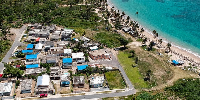 This June 18, 2018 file photo shows an aerial photo of the Viequez neighborhood, east of San Juan, Puerto Rico, where people were still living in damaged homes, protected by blue plastic tarps, nine months since Hurricane Maria devastated the island