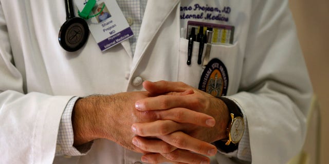 In a Friday, May 6, 2016 photo, Dr. Shane Prejean briefs a group of medical residents and medical students while visiting a patient at Our Lady of the Lake Regional Medical Center in Baton Rouge, La. Louisianas deep, persistent budget troubles are endangering the future of medical training programs. Proposed cuts to hospitals could damage the stream of new doctors for a generation, in a state that has chronic shortages of health care workers and some of the worst health care outcomes in the nation. (AP Photo/Gerald Herbert)