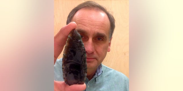 Karl Hutchings, an archaeologist at Thompson Rivers University in Canada, holds a Clovis spear point.