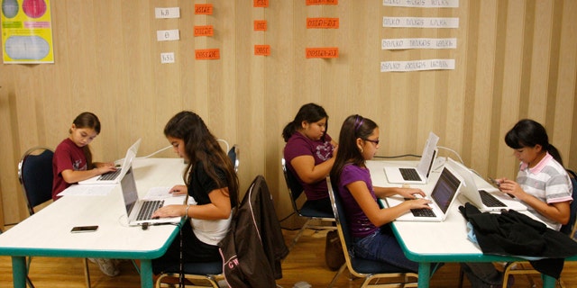 Students work at their computers in a classroom at the Cherokee Nation Immersion School in Tahlequah, Okla. Nearly two centuries after a Cherokee silversmith named Sequoyah developed a system of symbols for each syllable spoken by the Cherokee, the tribe's written language has become available on iPhone and iPods.