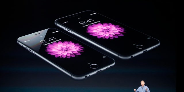 Phil Schiller, Senior Vice President at Apple Inc., speaks about the iPhone 6 (foreground) and the iPhone 6 Plus during an Apple event at the Flint Center in Cupertino, California, September 9, 2014. REUTERS/Stephen Lam (UNITED STATES - Tags: BUSINESS SCIENCE TECHNOLOGY TELECOMS) - RTR45LG0