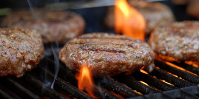Hamburgers being flame broiled on the gas grill
