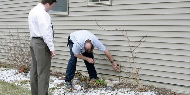 An appraiser checks out the exterior of a house.