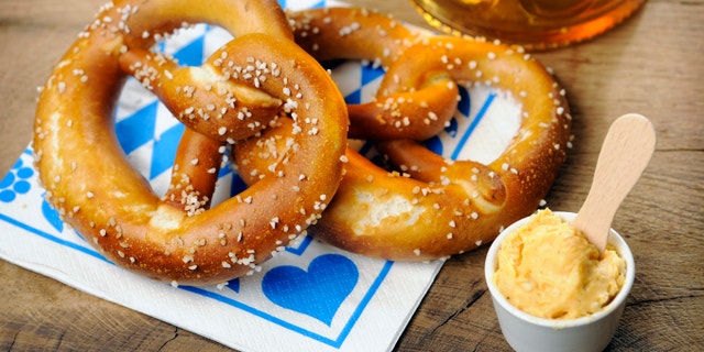 Pretzel, Obatzter (which is a traditional bavarian creme cheese) and beer on bavarian napkin; selective focus