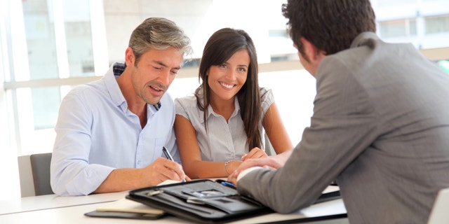 Father and teenager signing loan contract