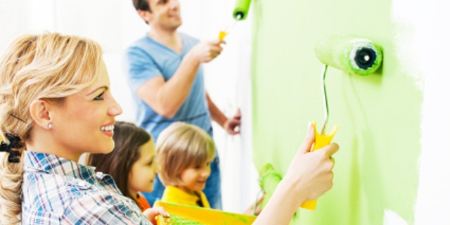 Happy family painting walls.