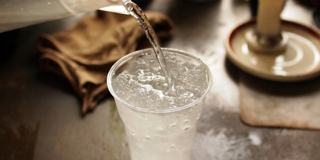pouring fresh water to glass of ice