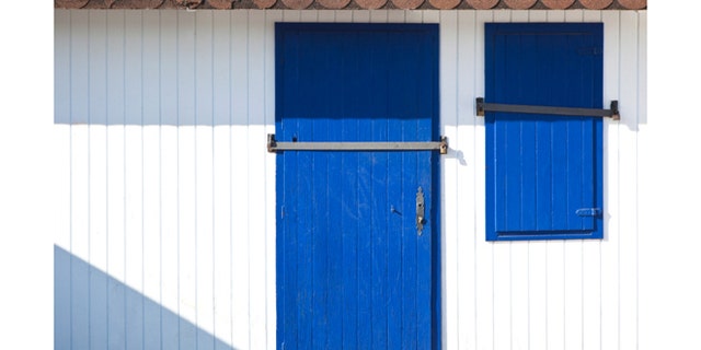Blue door and window of a closed beach hut.
