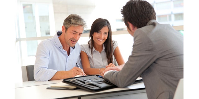 Father and teenager signing loan contract