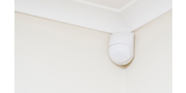 Security alarm sensor in corner of room.
