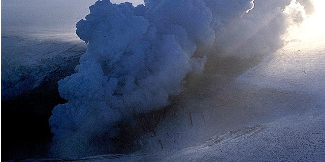 In this 2004 file photo, a cloud of ash erupts from Grimsvotn, a lake in the middle of Vatnajokull, the biggest glacier in Iceland. Torrents of water are pouring from a glacier that sits atop Iceland's most active volcano, an indication that the mountain is growing hotter and may be about to erupt, scientists said Monday, Nov. 1, 2010.