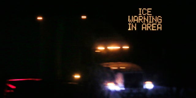 Jan. 14, 2017: Traffic moves past an icing warning sign at night on I-70 west of Lawrence, Kan.