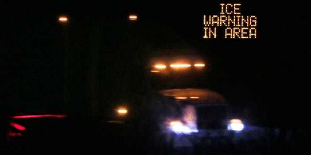 Jan. 14, 2017: Traffic moves past an icing warning sign at night on I-70 west of Lawrence, Kan.