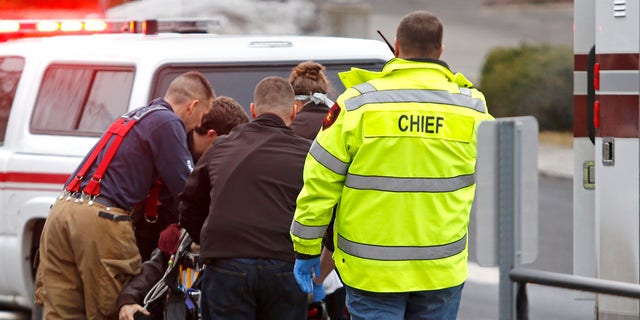 Jan. 10, 2015: Emergency medical technicians rush one of two shooting victims to an ambulance after they were shot in an office in Moscow, Idaho
