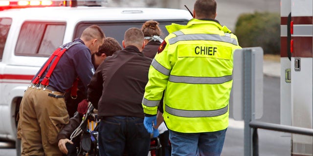 Jan. 10, 2015: Emergency medical technicians rush one of two shooting victims to an ambulance after they were shot in an office in Moscow, Idaho