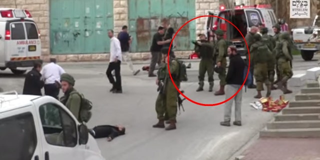 Circled in red: An Israeli soldier seen holding a gun before firing at a Palestinian protester on the ground.
