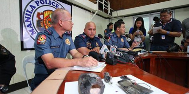 Officials sit near the bomb that two militants planned to explode at the U.S. Embassy