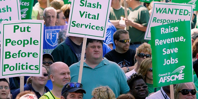 FILE: In this April 21, 2010, file photo, thousands of people, including state union members, state workers, teachers and social service organizations rally to protest budget cuts at the Illinois State Capitol in Springfield, Ill.