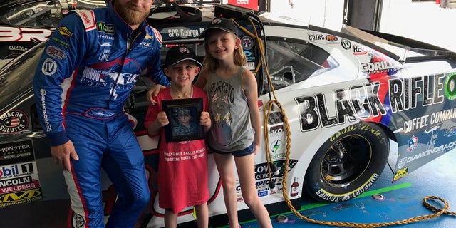Jeffrey Earnhardy posing with Gino and Kayden Manis after revealing their father's name on his car.