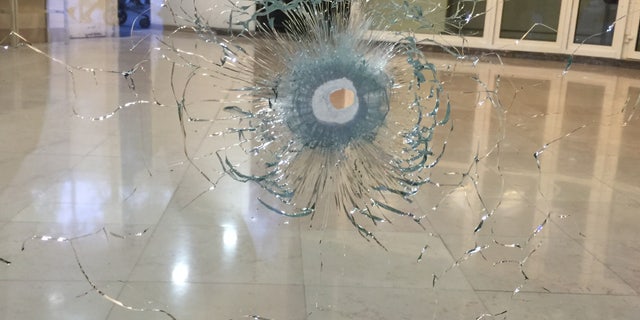 A window broken by a bullet.