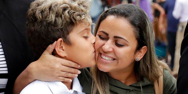 Diego Magalhaes, left, 10, kisses his mother Sirley Silveira, Paixao, an immigrant from Brazil seeking asylum with her son, after Diego was released from immigration detention, Thursday, July 5, 2018, in Chicago. (AP Photo/Charles Rex Arbogast)