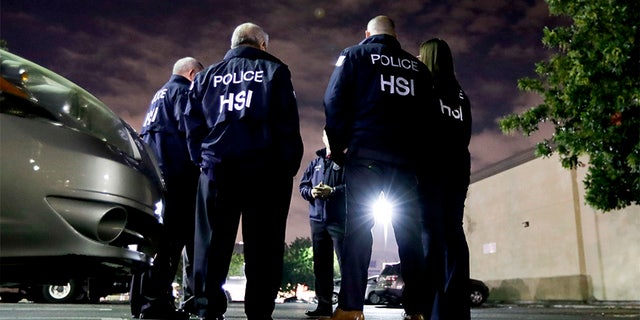 U.S. Immigration and Customs Enforcement agents gather before serving a employment audit notice at a 7-Eleven convenience store Wednesday, Jan. 10, 2018.