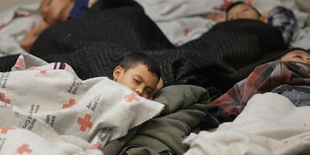 FILE - This June 18, 2014, file photo, detainees sleep in a holding cell at a U.S. Customs and Border Protection, processing facility in Brownsville,Texas. Immigration courts backlogged by years of staffing shortages and tougher enforcement face an even more daunting challenge since tens of thousands of Central Americans began arriving on the U.S. border fleeing violence back home. For years, children from Central America traveling alone and immigrants who prove they have a credible fear of returning home have been entitled to a hearing before an immigration judge. (AP Photo/Eric Gay, Pool, File)
