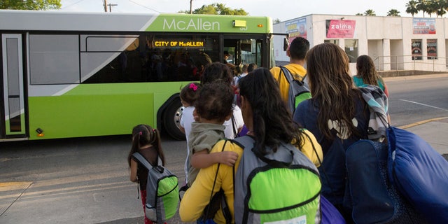 FILE - In this file photo from April 30, 2015, immigrant families, many of them mothers with children, board a bus headed to the downtown bus station in McAllen, Texas. (AP Photo/Seth Robbins, File)