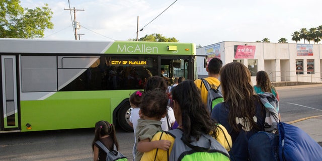 FILE - In this file photo from April 30, 2015, immigrant families, many of them mothers with children, board a bus headed to the downtown bus station in McAllen, Texas. (AP Photo/Seth Robbins, File)
