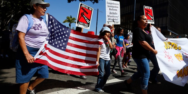 People march through the streets during a May Day demonstration in San Diego, California May 1, 2013.