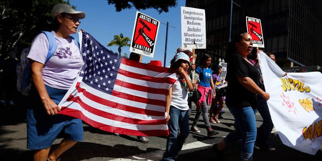 People march through the streets during a May Day demonstration in San Diego, California May 1, 2013.
