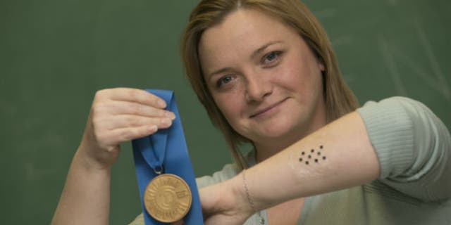 Sawicka, shown wearing a sample of the ImmunoMatrix patch, with her medal for winning first prize in the graduate division of the national Collegiate Inventors Competition. (image courtesy subject)