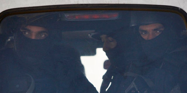 Jan. 5, 2016: Indian military commandos look from inside a vehicle at the Indian air force base in Pathankot, India.
