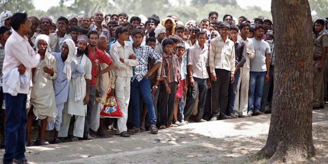 May 31, 2014: Onlookers stand at the site where two teenage girls, who were raped, were hanged from a tree in the northern Indian state of Uttar Pradesh.