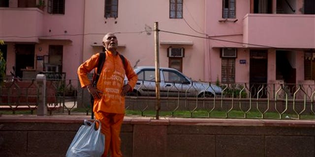 In this June 27, 2015 photo, Omkarnath, who goes by the name "Medicine Baba" calls out to people to donate unused medicines at a government colony in New Delhi, India. The chatty, 79-year-old retired blood-bank technician has been collecting unused prescription drugs from the affluent for the past eight years, and distributing whatever hasn't expired to patients who need medicines they cannot afford. (AP Photo/Saurabh Das)