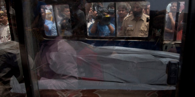 An ambulance carries on of the 11 bodies found in Burari village, north Delhi, India, Sunday, July 1, 2018.