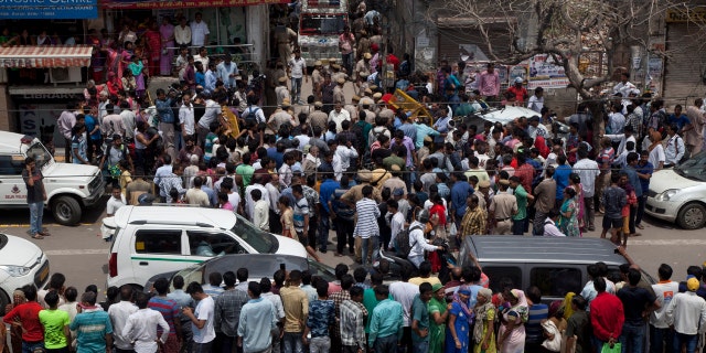 An ambulance carries one of the 11 dead bodies found in Burari village, north Delhi, India, Sunday, July 1, 2018.