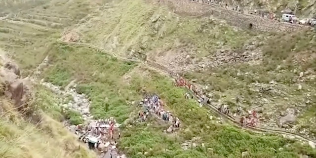 In this grab made from video provided by KK Productions, shows the area of a deadly bus accident in Uttarakhand's Paudi Garhwal district, northern India, Sunday, July 1, 2018. Chief Minister of Uttarakhand state Trivendra Rawat said the bus fell into a 700-foot (213-meter) deep gorge in the Himalayan foothills. (KK Production via AP)