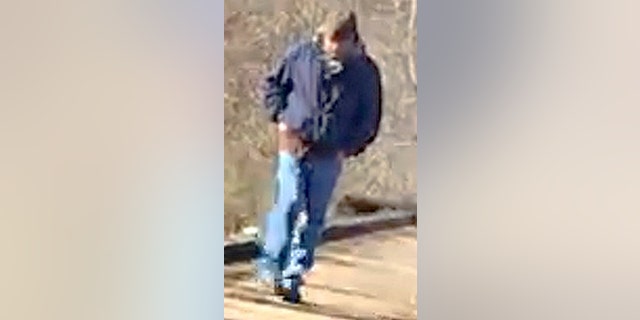 This Feb. 13, 2017, photo released by the Indiana State Police shows a man walking along the trail system in Delphi, Ind. Indiana authorities say the man is the suspect in the killings of two teenage girls, Liberty German and Abigail Williams. He was photographed on the trail system around the time German, age 14, and Williams, age 13, were dropped off Monday Feb. 13, 2017, to go hiking. The photo is from victim Abby German's cell phone that was recovered at the scene of the crime. (Indiana State Police via AP)