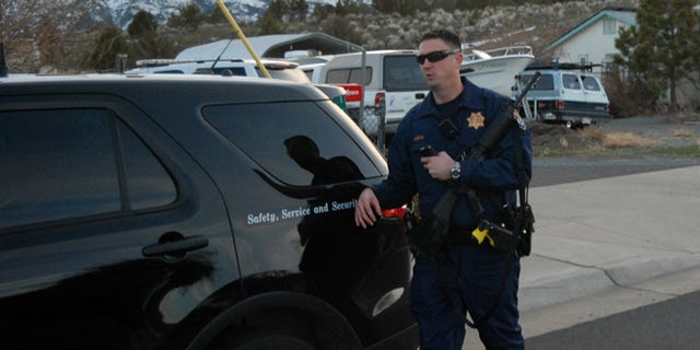 An unidentified California Highway Patrolman leaves the home of former Cedarville Rancheria chairwoman Cherie Lash Rhoades on Friday, Feb. 21, 2014 in Cedarville, Calif., where police served a search warrant. Rhoades is being held on suspicion she killed four people and wounded two others at a tribal meeting in Alturas, Calif., held to consider her eviction. (AP Photo/Jeff Barnard)