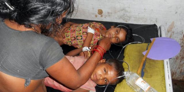 July 16, 2013: Schoolchildren receive treatment at a hospital after falling ill soon after eating a free meal at a primary school in Chhapra district, in the eastern Indian state of Bihar.