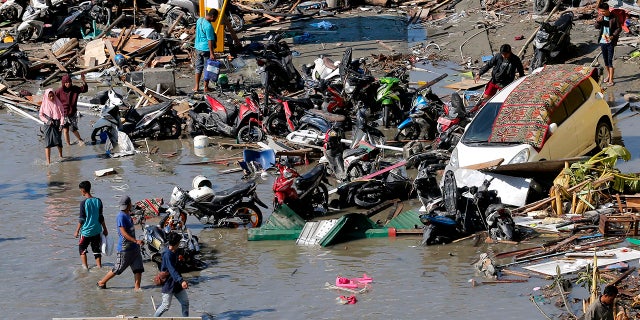 People survey damage outside the shopping mall following earthquakes and tsunami in Palu, Central Sulawesi, Indonesia, Sept. 30, 2018.