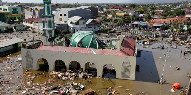 People survey the mosque damaged following earthquakes and tsunami in Palu, Central Sulawesi, Indonesia, Sept. 30, 2018.
