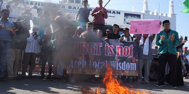 Muslim protesters pray as they burn an effigy during an anti-LGBT rally in Banda Aceh, Indonesia, Friday, Feb. 2, 2018.