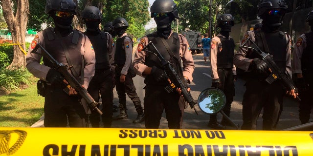 Police officers stand guard near the site where an explosion went off at Santa Maria church in Surabaya, East Java, Indonesia, May 13, 2018.